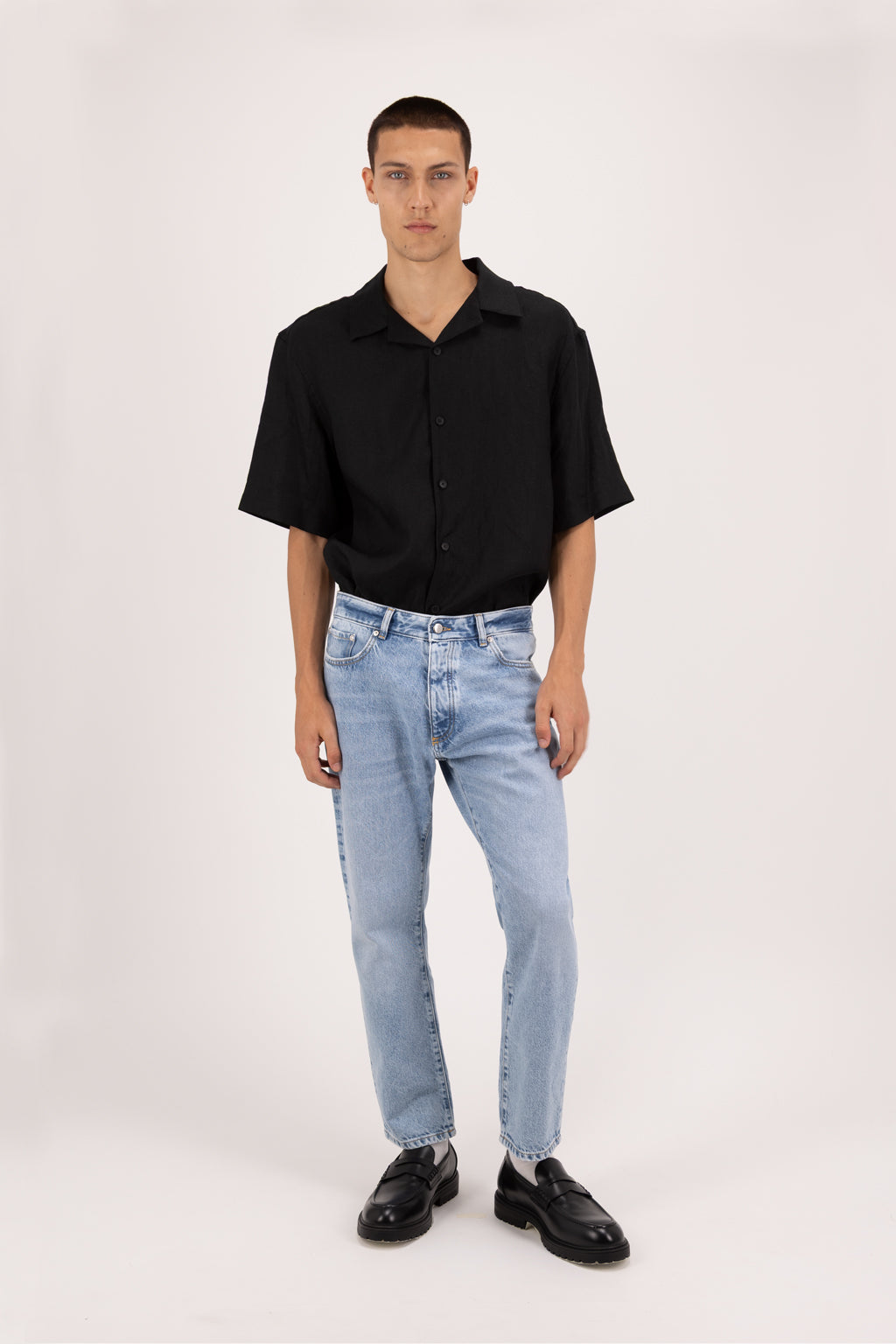Josh men’s carrot jeans in sky blue wash, 100% rigid cotton denim, worn by a model with a black shirt.