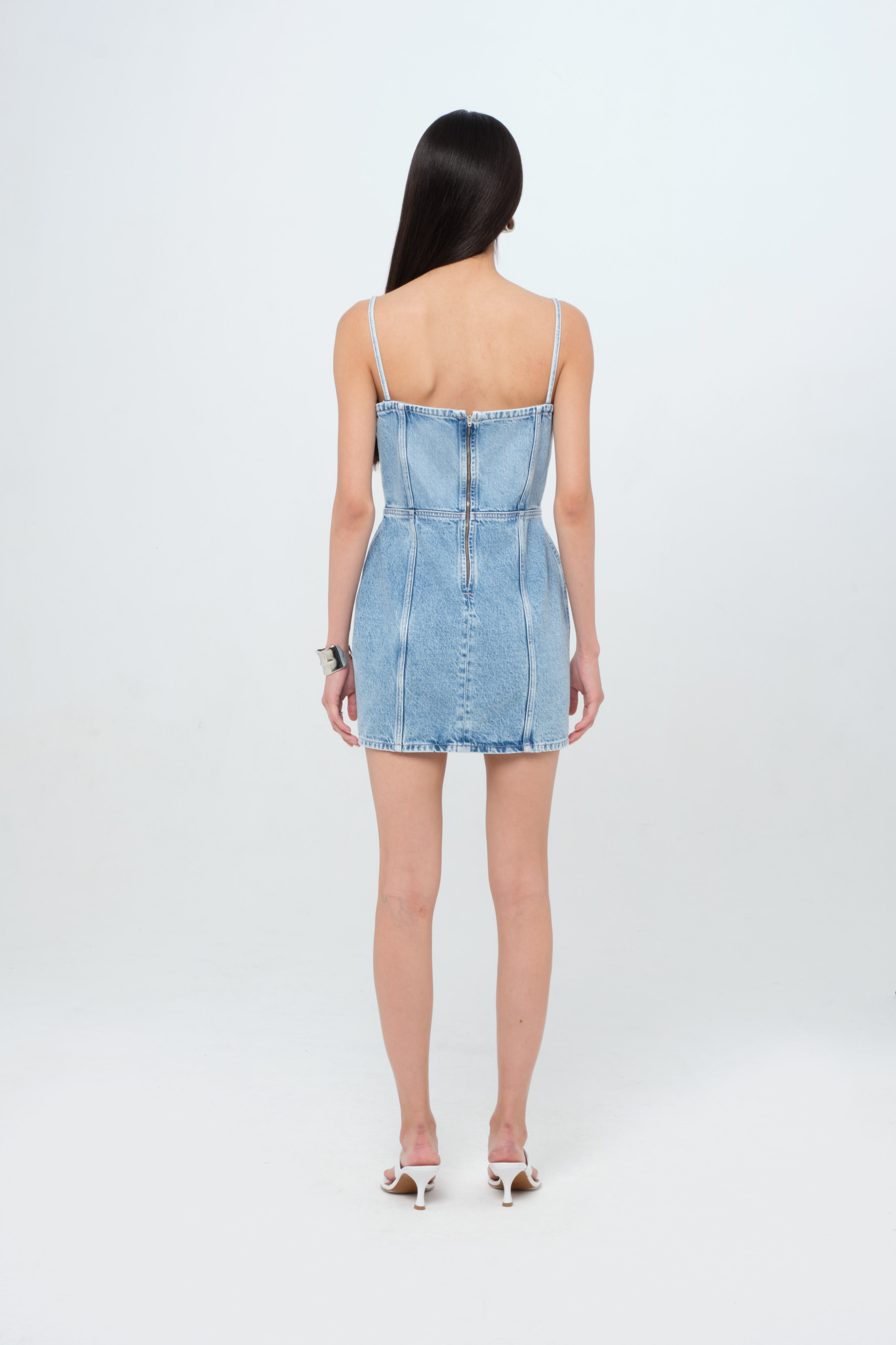 Back view of Judy women’s dress in light wash, 100% rigid cotton denim, worn by a model.