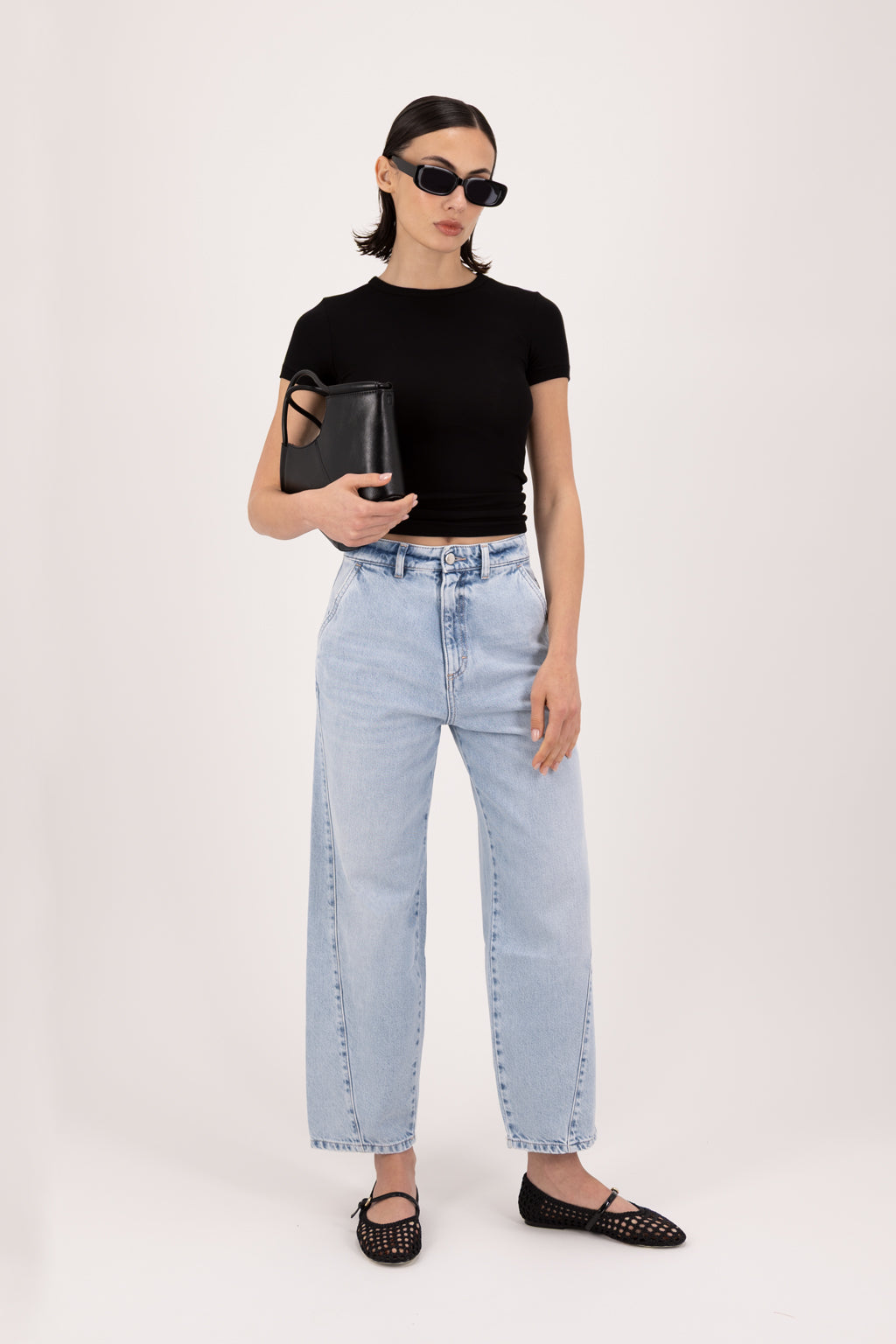 Juno women’s carrot jeans in sky blue wash, 100% rigid cotton denim, worn by a model with a black top.