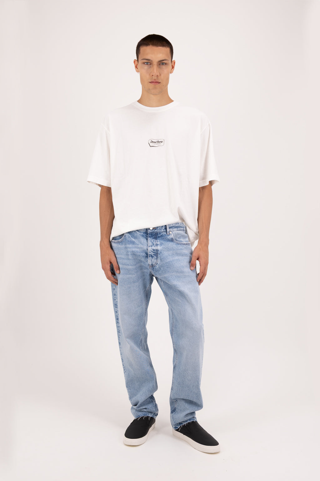 Kanye Eco men’s baggy jeans in arid blue wash, 100% organic rigid cotton denim, worn by a model with a white t-shirt.