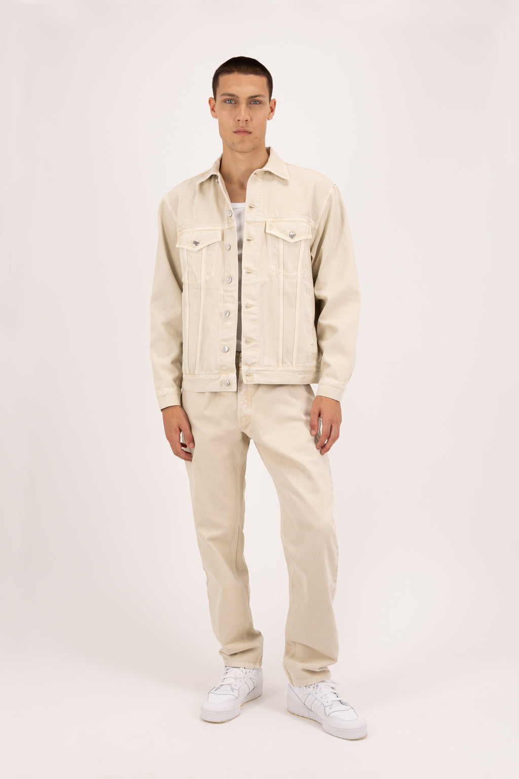 Kanye men’s baggy jeans in desert wash, 100% rigid soft cotton denim, worn by a model with a denim jacket.
