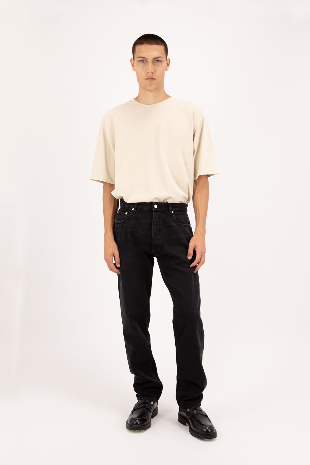 Kanye men’s baggy jeans in graphite black wash, 100% rigid soft cotton denim, worn by a model with a desert t-shirt.