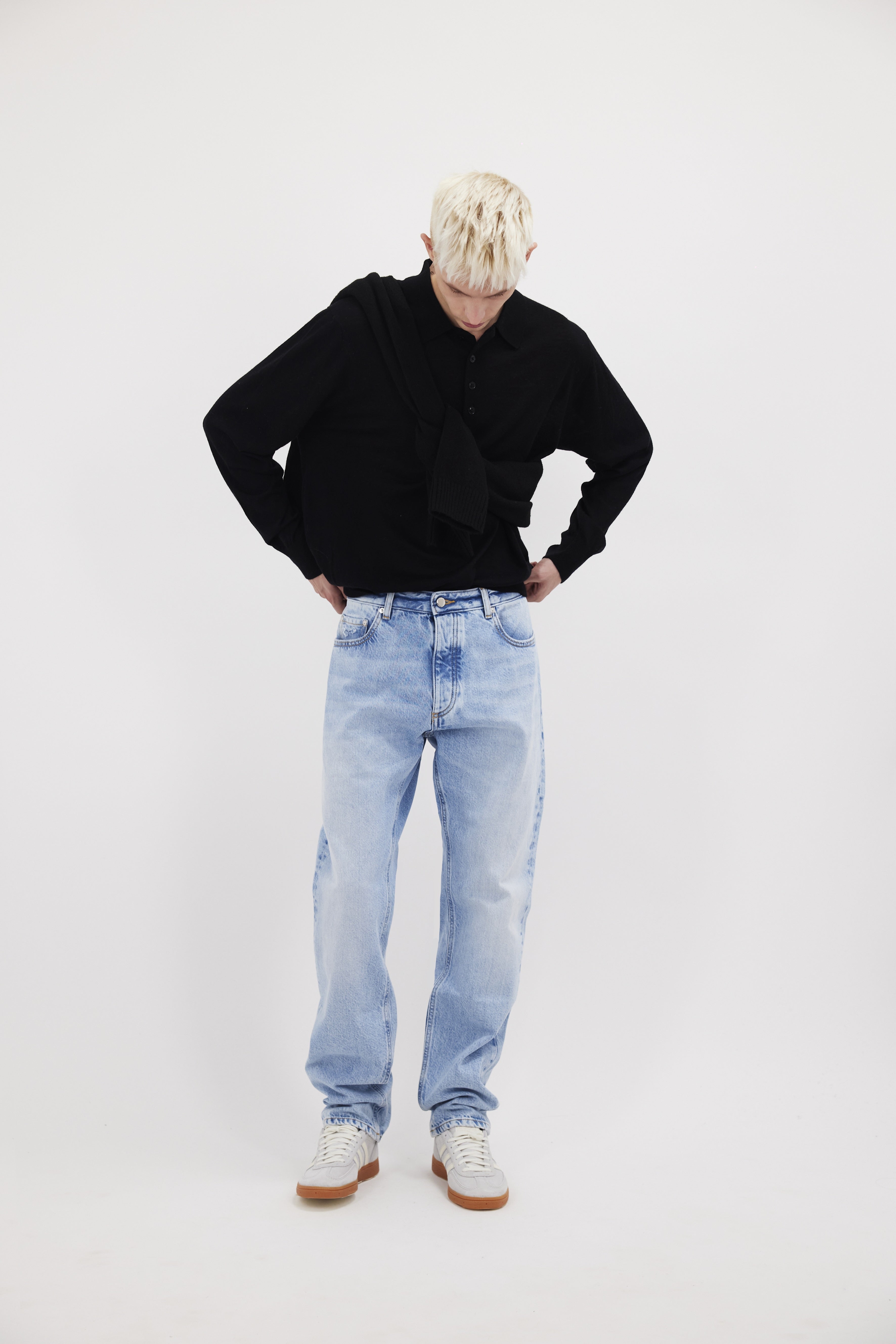 Kanye men’s loose jeans in sky blue wash, 100% rigid cotton denim, worn by a model with a black longsleeve.