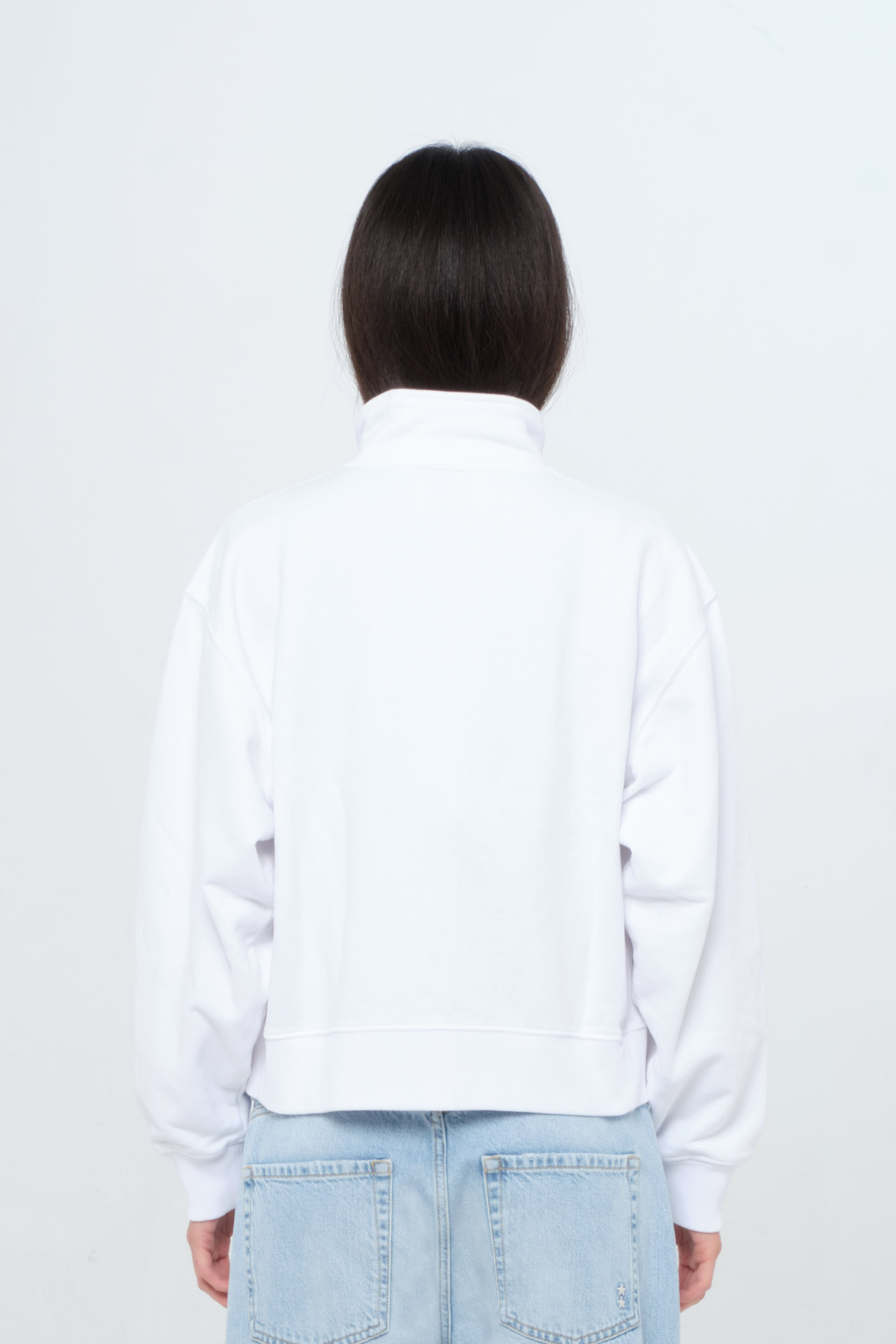Back view of Kara women’s sweatshirt in white, 100% cotton, worn by a model with jeans.