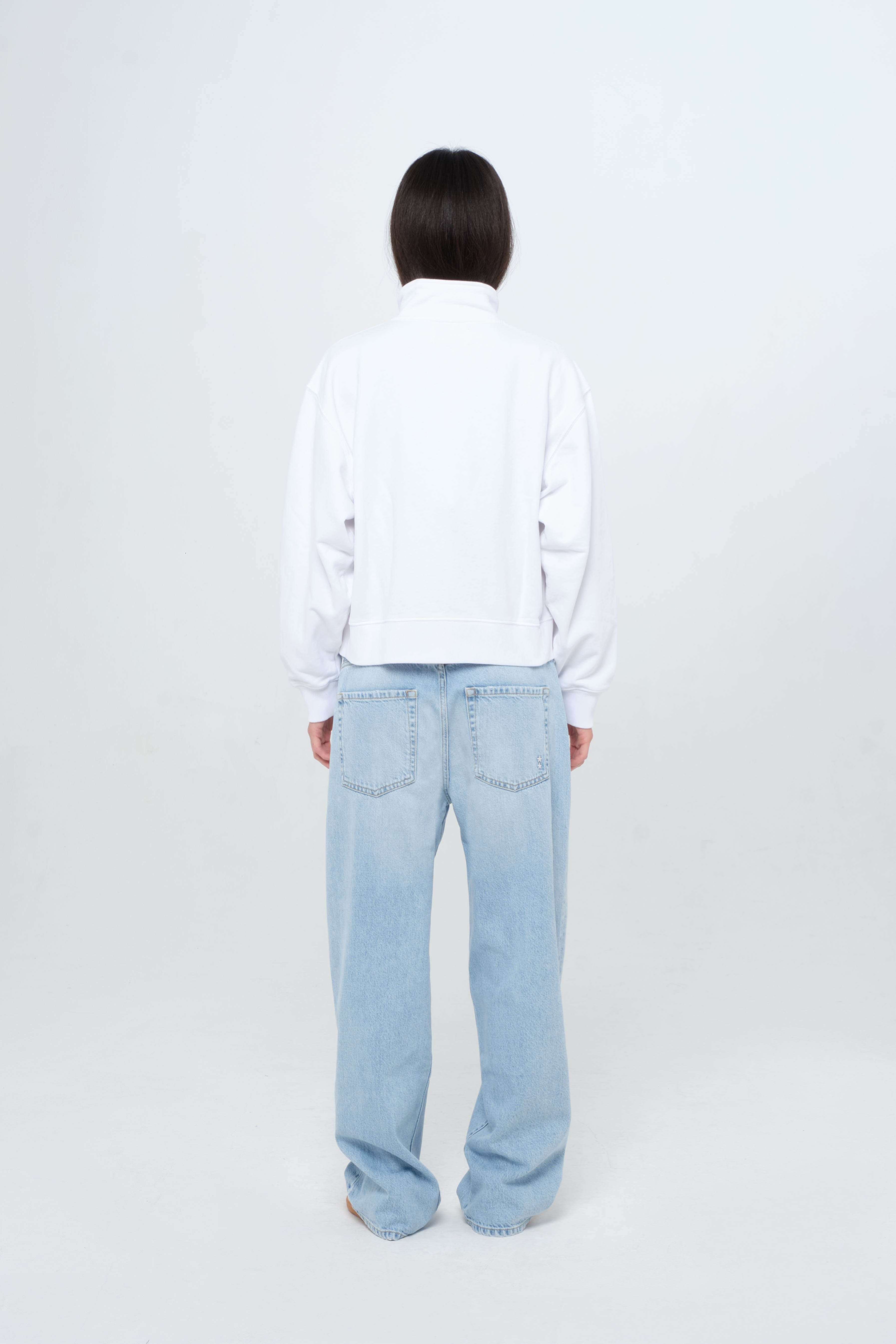 Back view of Kara women’s sweatshirt in white, 100% cotton, worn by a model with jeans.