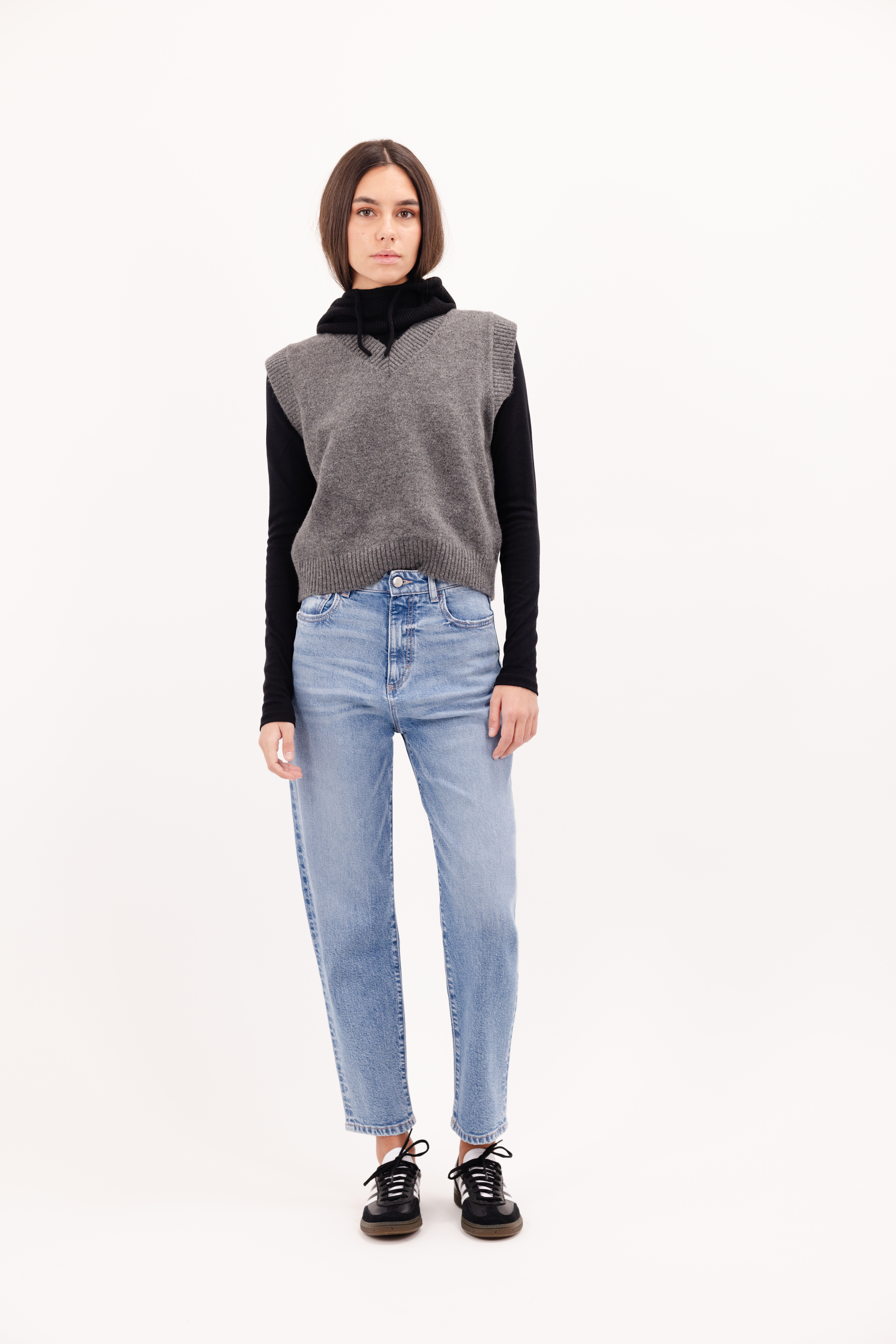 Karolina women’s carrot jeans in misty blue wash, 99% cotton denim and 1% Elastan fibers, worn by a model with a gray knit.