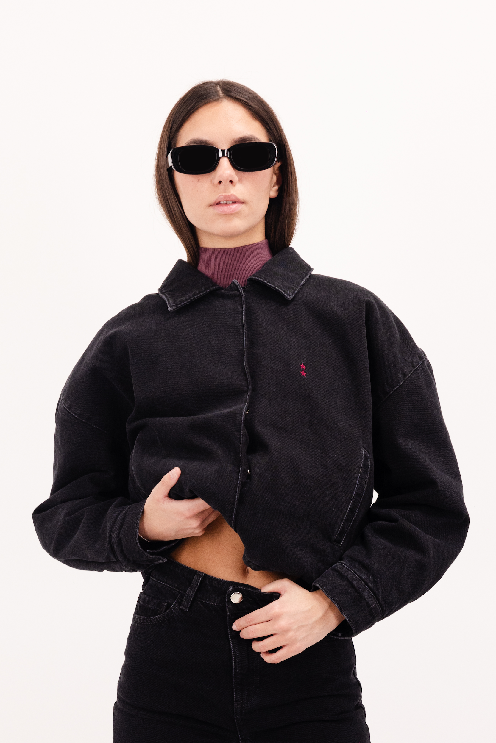 Kleo women’s jacket in graphite black wash, 100% rigid cotton denim, worn by a model with jeans.