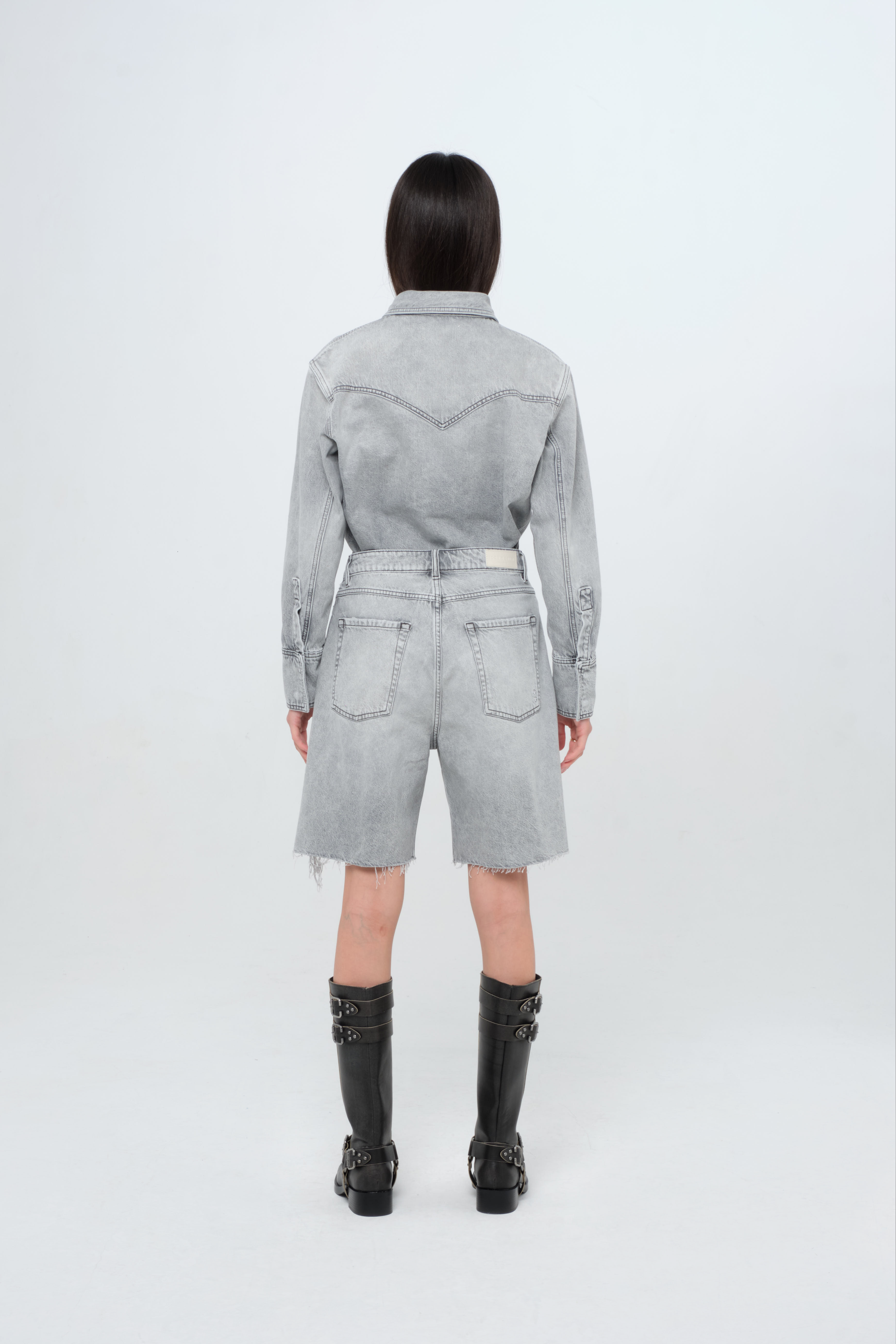 Back view of Lea women’s wide leg jeans in gray wash, 100% rigid cotton denim, worn by a model with a denim shirt.
