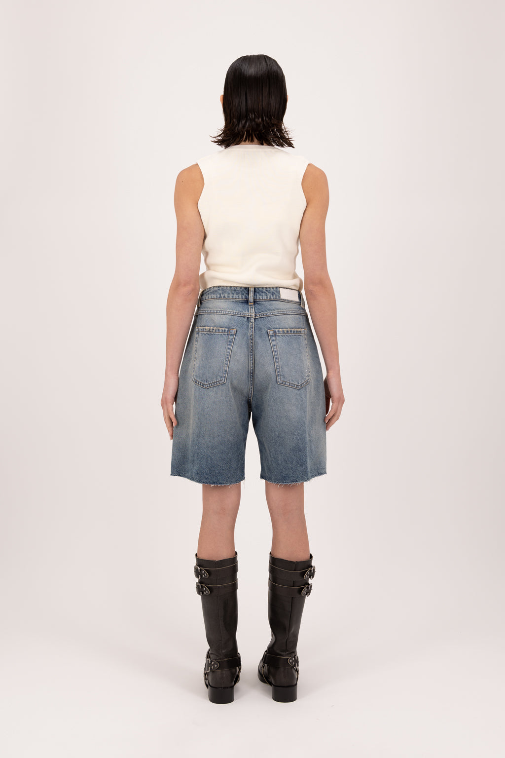 Back view of Lea women’s wide leg short jeans in smoke blue wash, 100% rigid cotton denim, worn by a model with a white top.