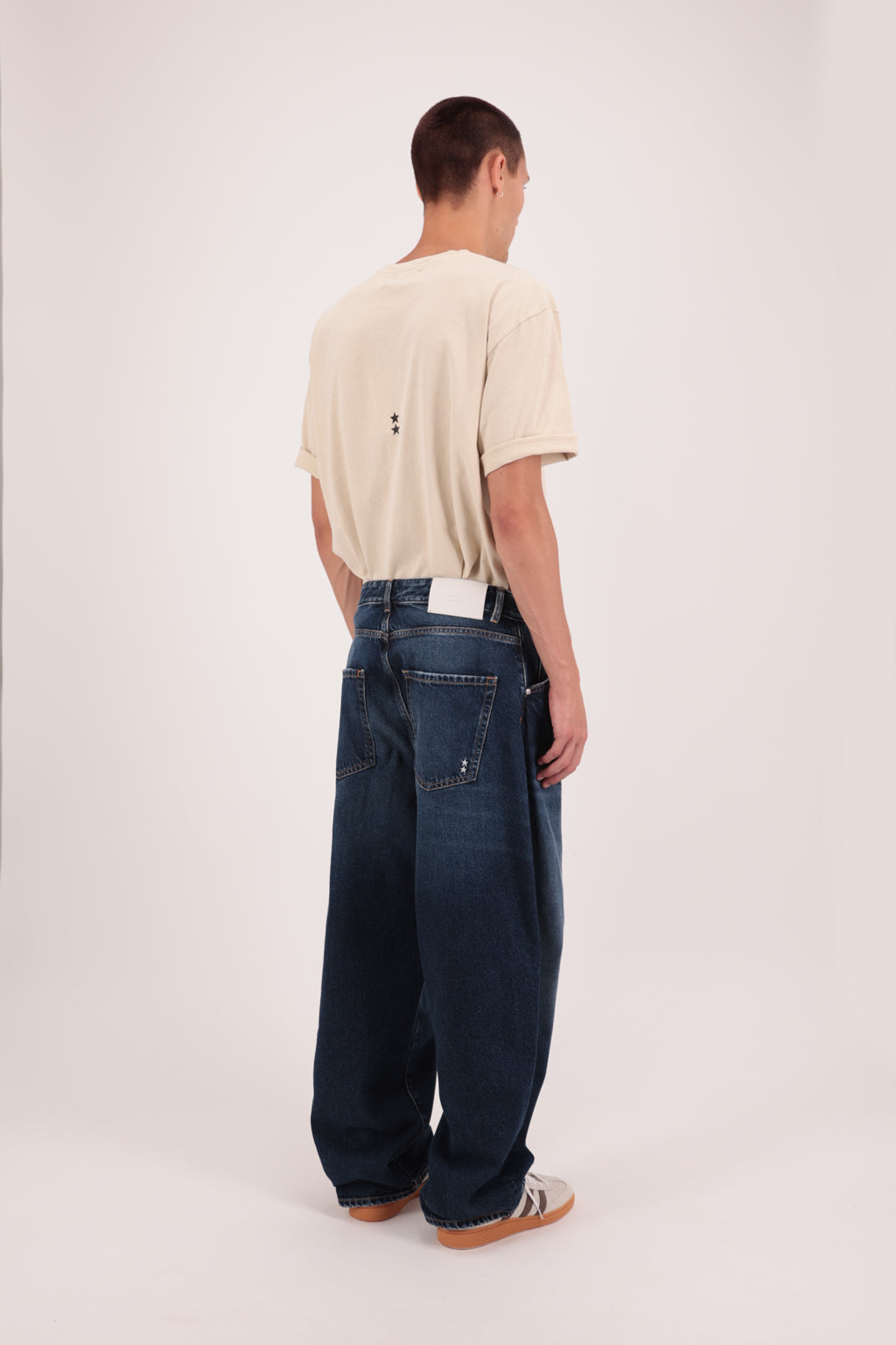 Back view of Lee men’s wide leg jeans in deep blue wash, 100% rigid cotton denim, worn by a model with a desert t-shirt.