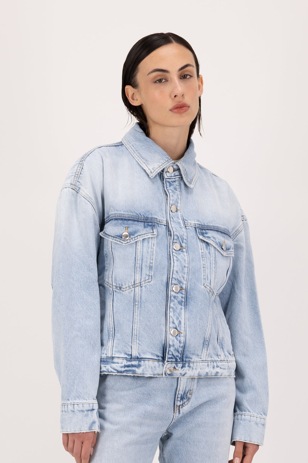 Lori women’s jacket in sky blue wash, 100% rigid cotton denim, worn by a model with jeans.