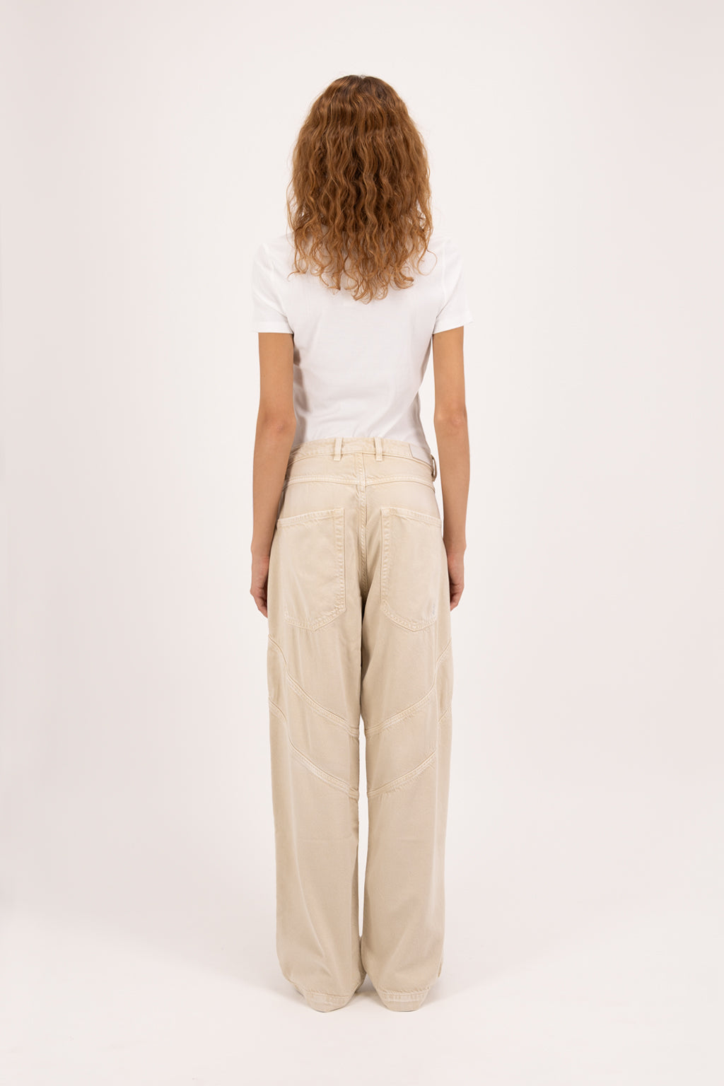 Back view of Lysa women’s wide leg jeans in desert wash, 100% rigid soft cotton denim, worn by a model with a white t-shirt.