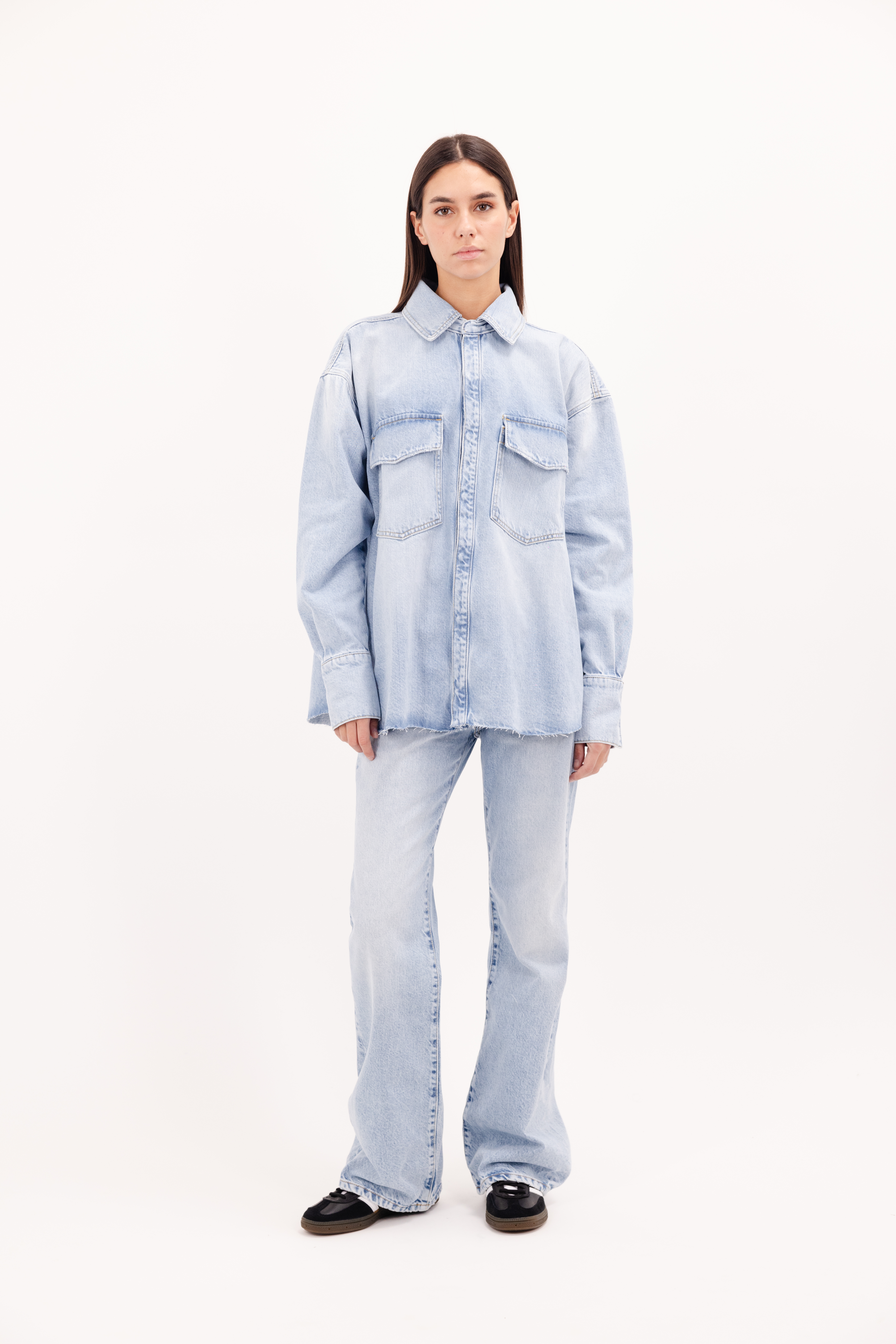 Mila women’s oversize shirt in bleached wash, 100% rigid cotton denim, worn by a model with jeans.