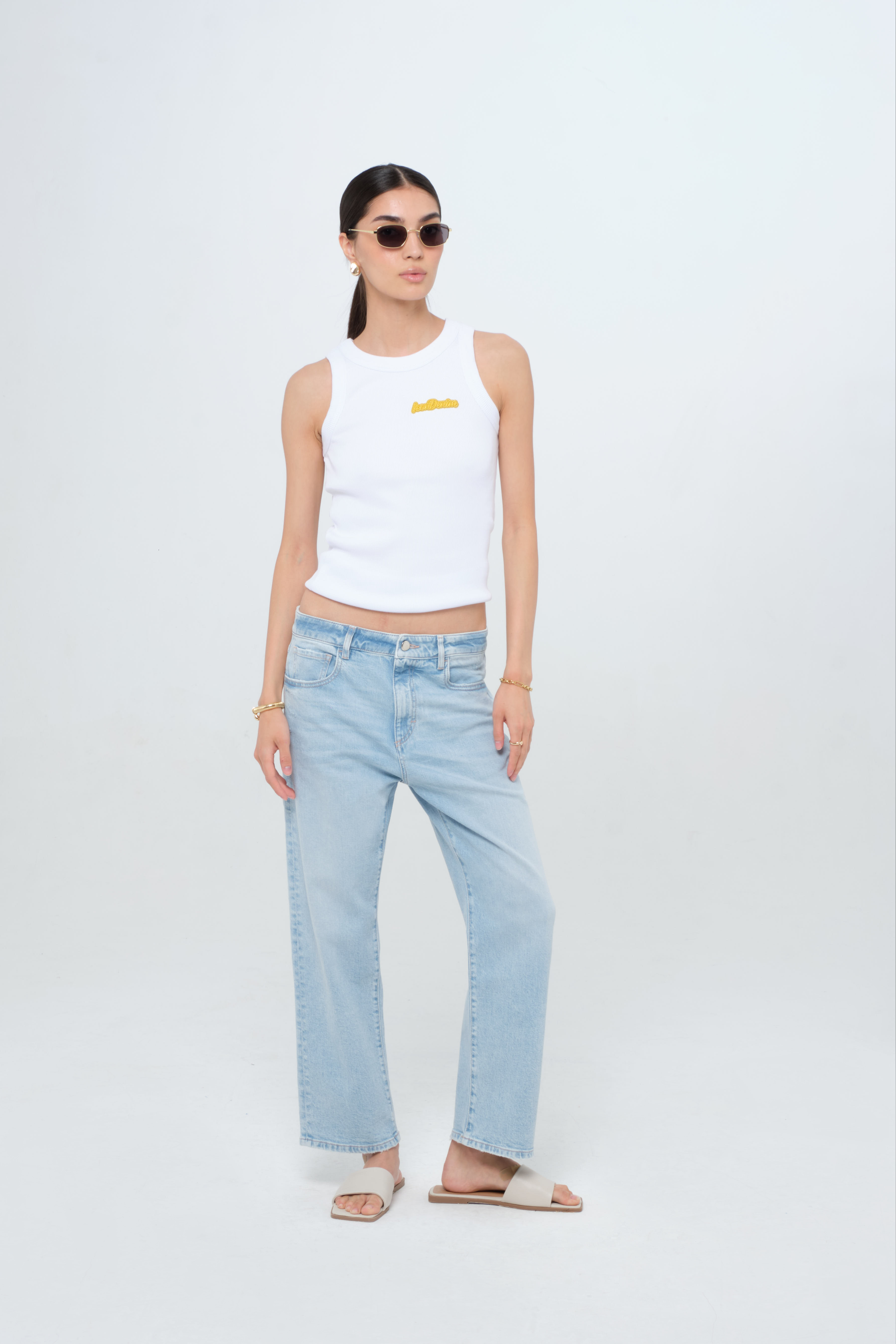 Mimi women’s straight leg jeans in light wash, 100% rigid cotton denim, worn by a model with a white tank top.

