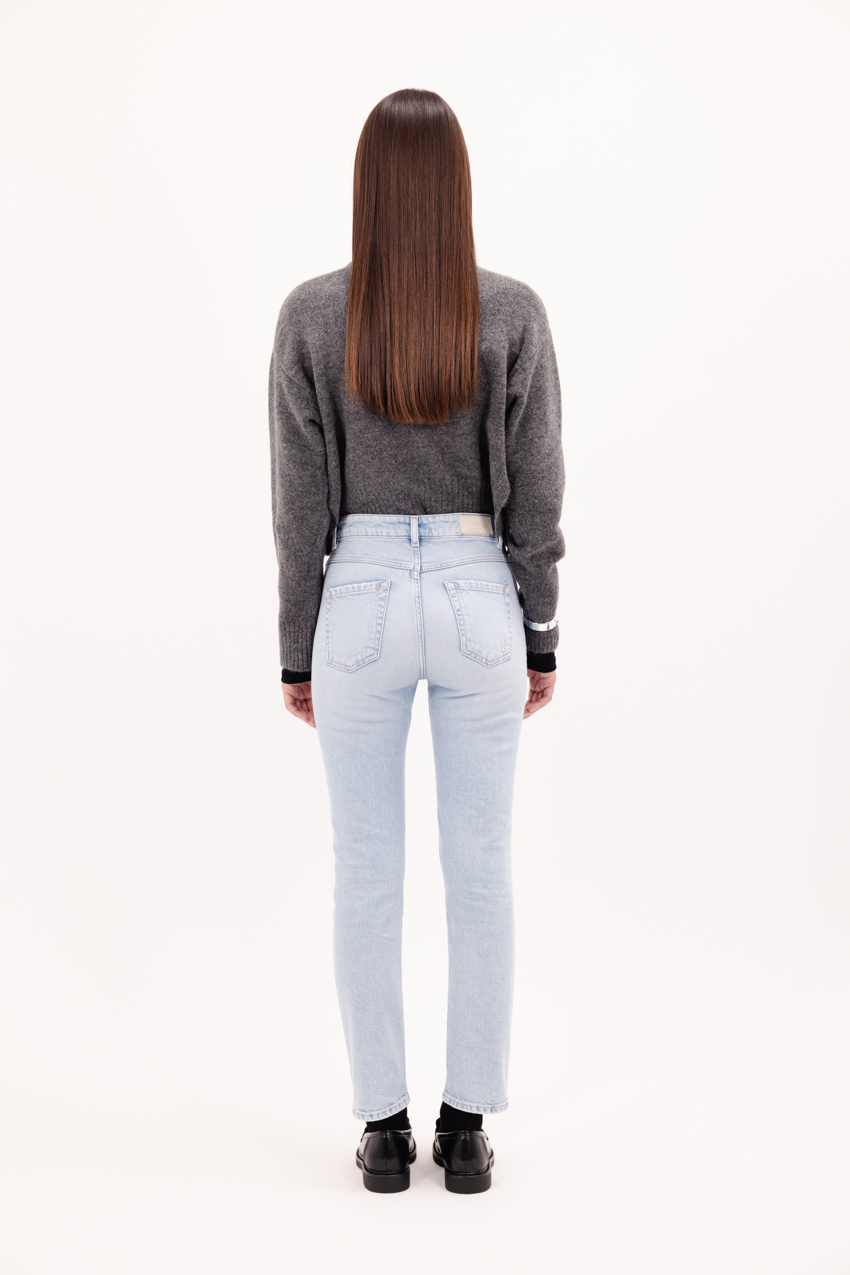 Back view of Nana women's slim jeans in sky blue wash, 99% Co + 1% Ela, worn by a model with a gray knit.