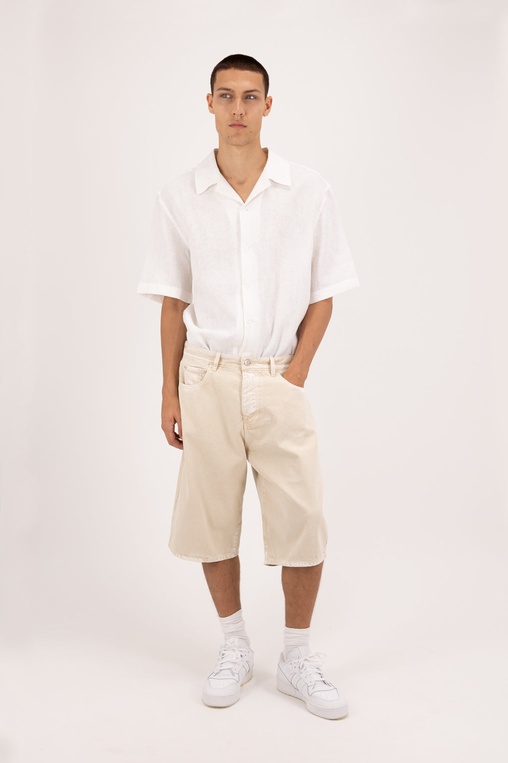 Bobby men’s wide leg short jeans in desert wash, 100% rigid soft cotton denim, worn by a model with a white shirt.