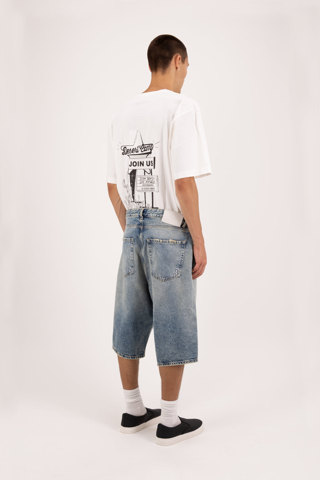 Back view of Bobby men’s wide leg short jeans in smoke blue wash, 100% rigid cotton denim, worn by a model with a white t-shirt.