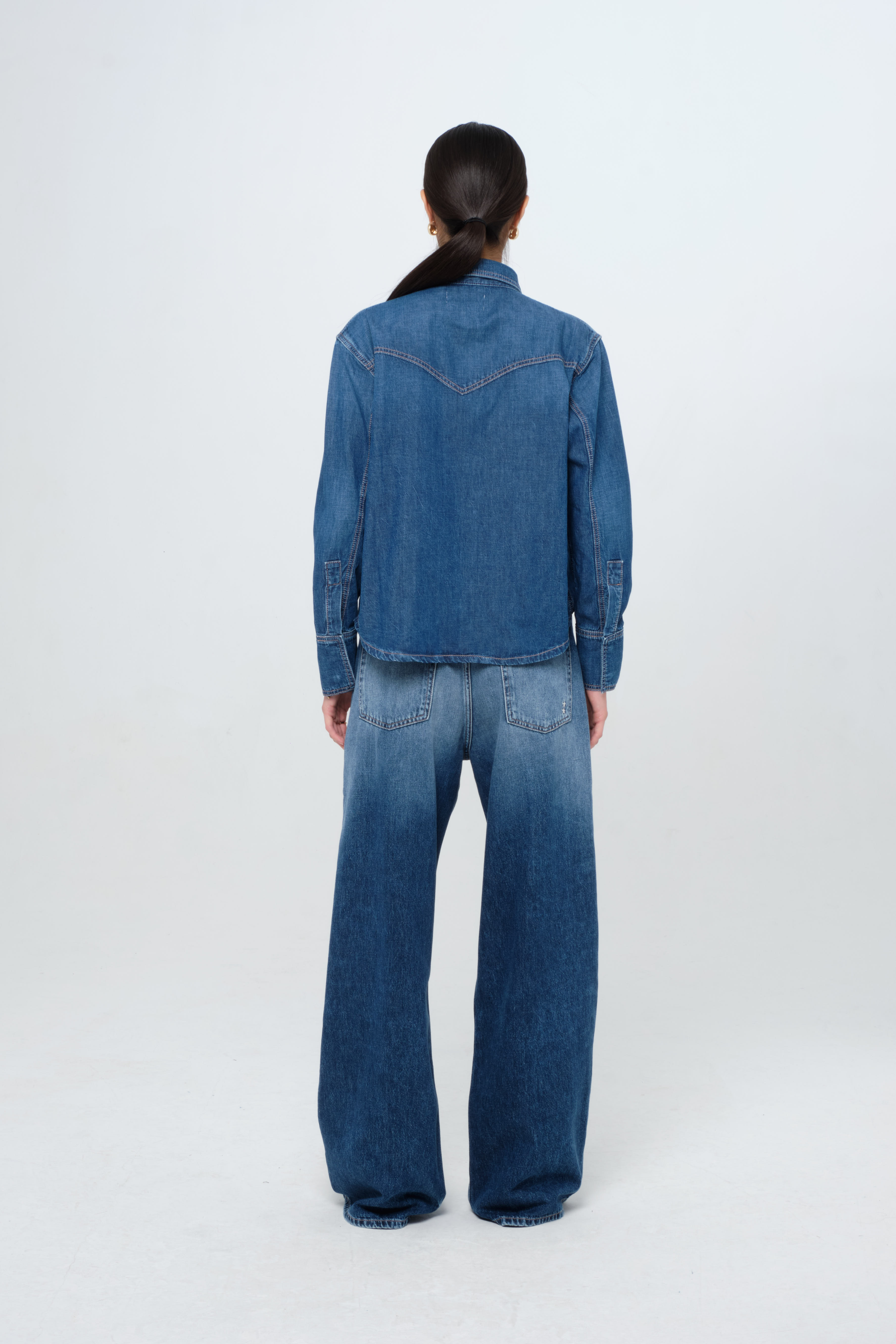 Back view of Norah women’s in dark wash, 100% rigid soft cotton denim, worn by a model with jeans.