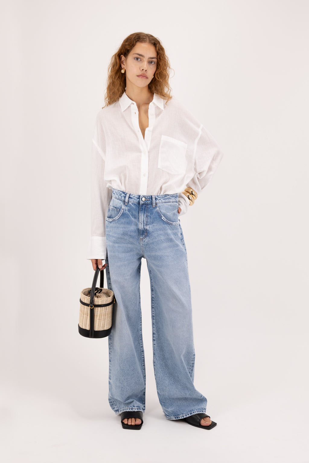 Poppy Eco women’s wide leg jeans in arid blue wash, 100% organic rigid cotton denim, worn by a model with a white shirt.