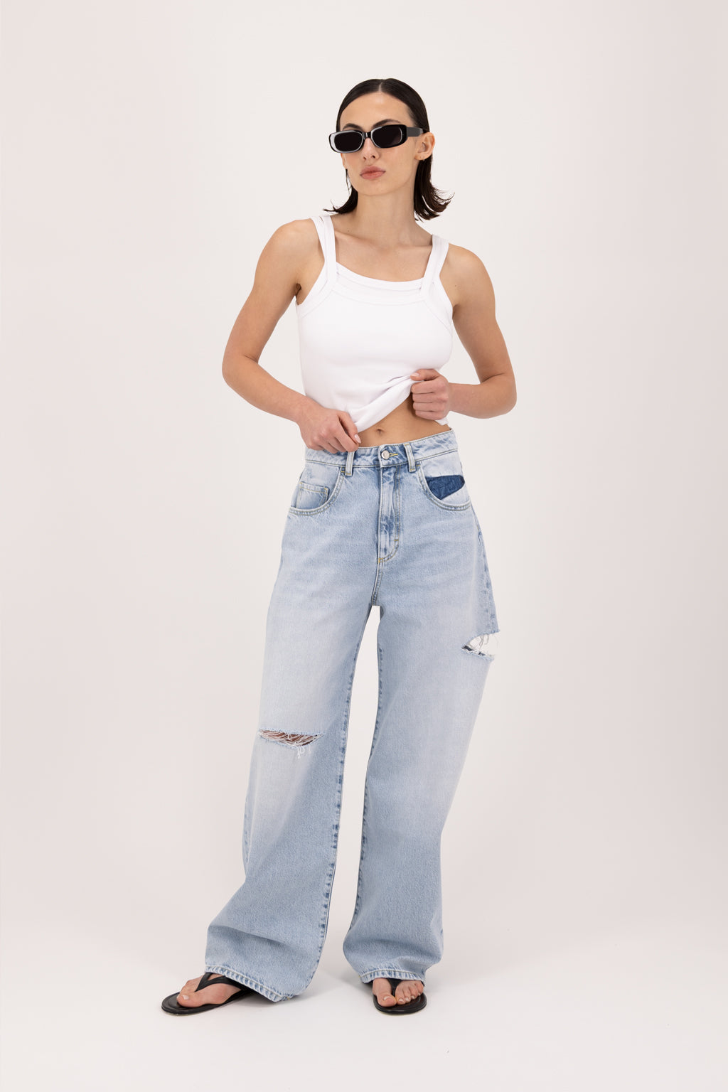 Poppy women’s wide leg jeans in sky blue wash, 100% rigid cotton denim, worn by a model with a white top.