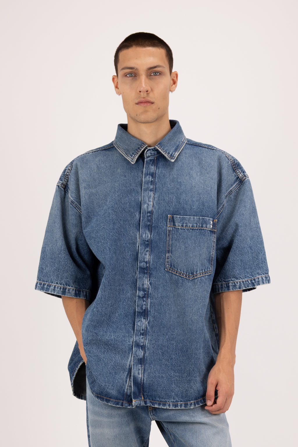 Ray men’s oversize shirt in eclipse wash, 100% rigid cotton denim, worn by a model with jeans.