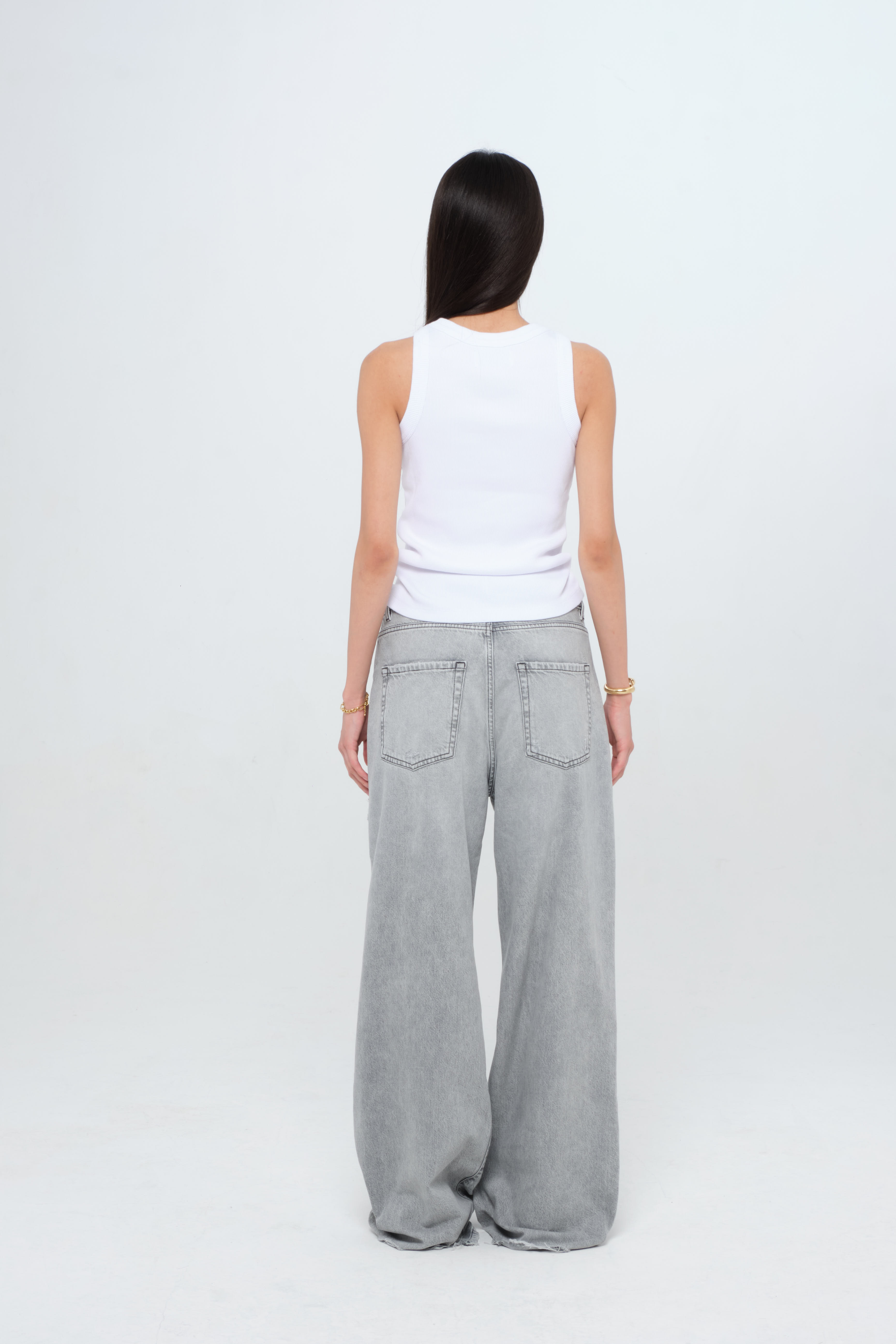 Back view of Raya women’s tank top in white, 50% Md - 49% Co - 1% Ea, worn by a model with jeans.
