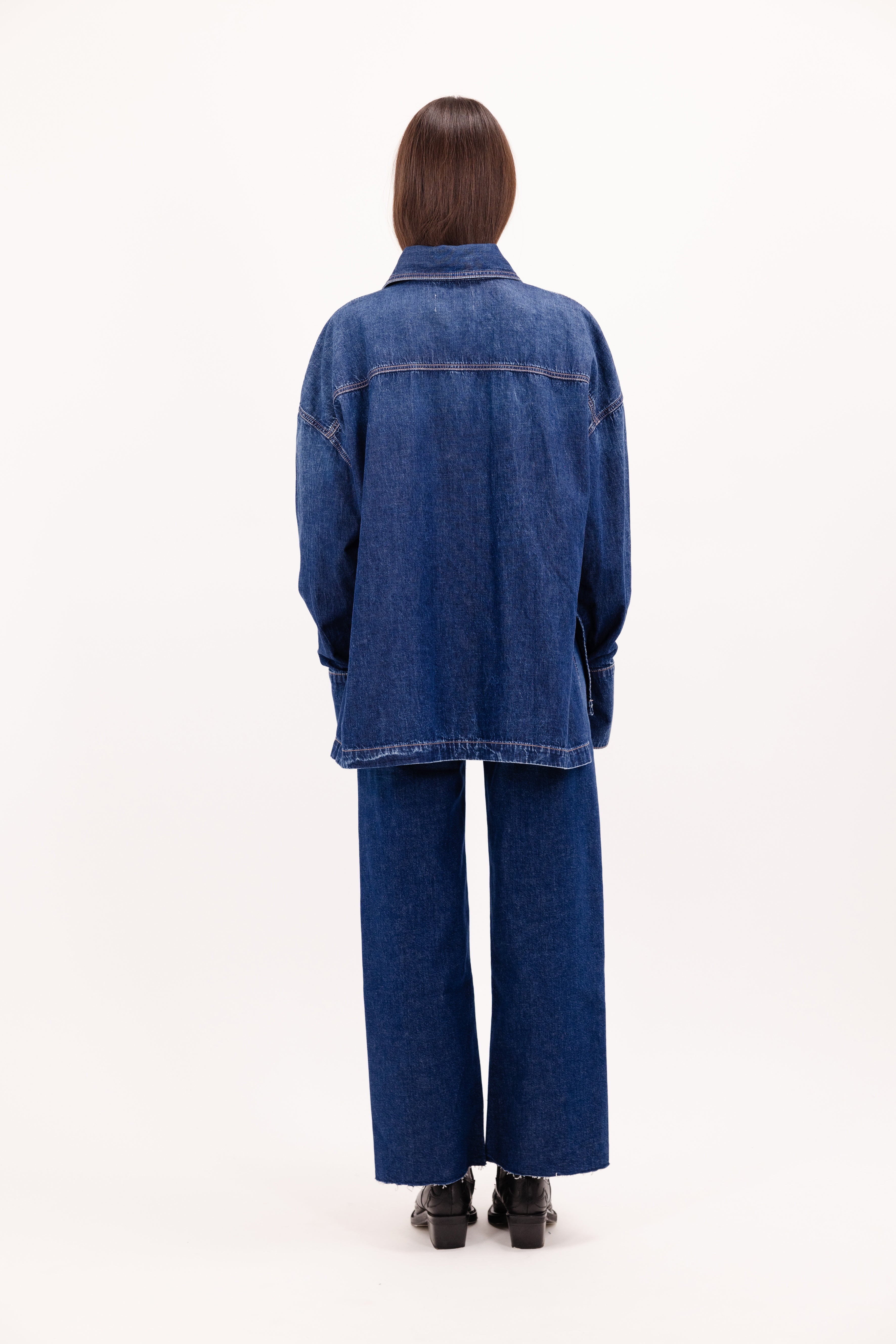 Back view of Rena women’s shirt in eclipse wash, 100% rigid soft cotton denim, worn by a model with jeans.