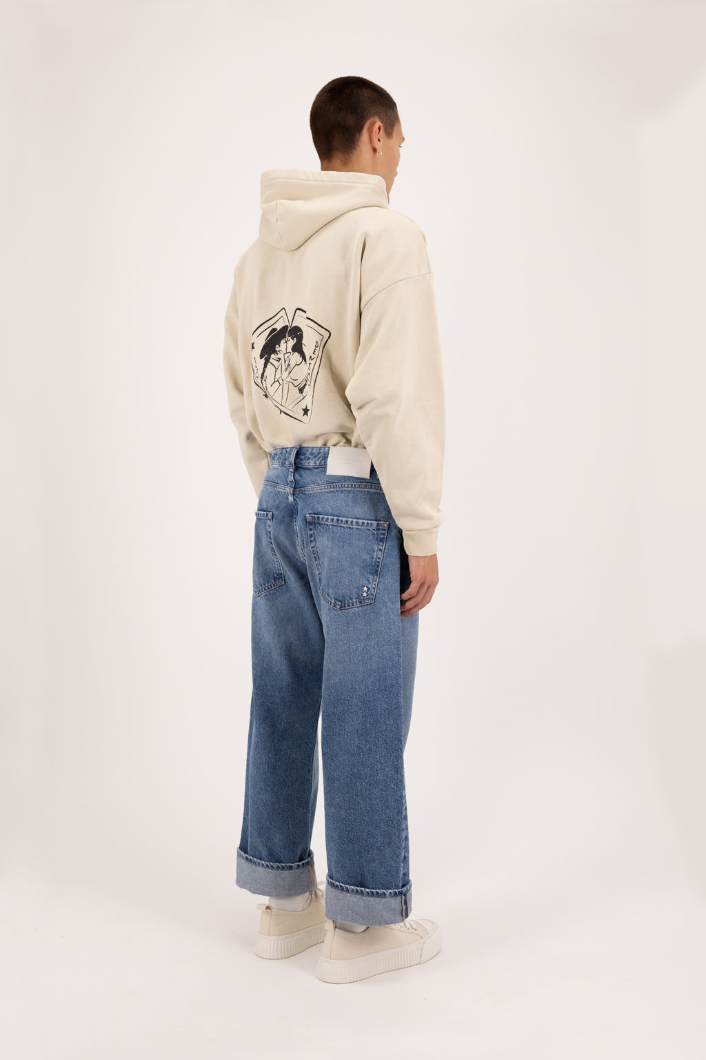 Back view of Ross men’s baggy jeans in eclipse wash, 100% rigid cotton denim, worn by a model with a desert hoodie.