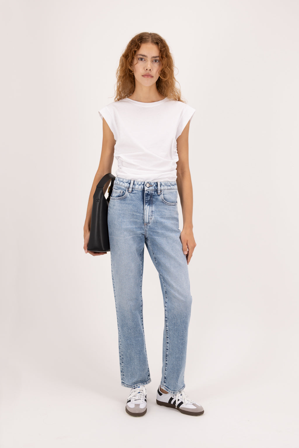 Roxy women’s slim flared leg jeans in river wash, 100% rigid cotton denim, worn by a model with a white top.