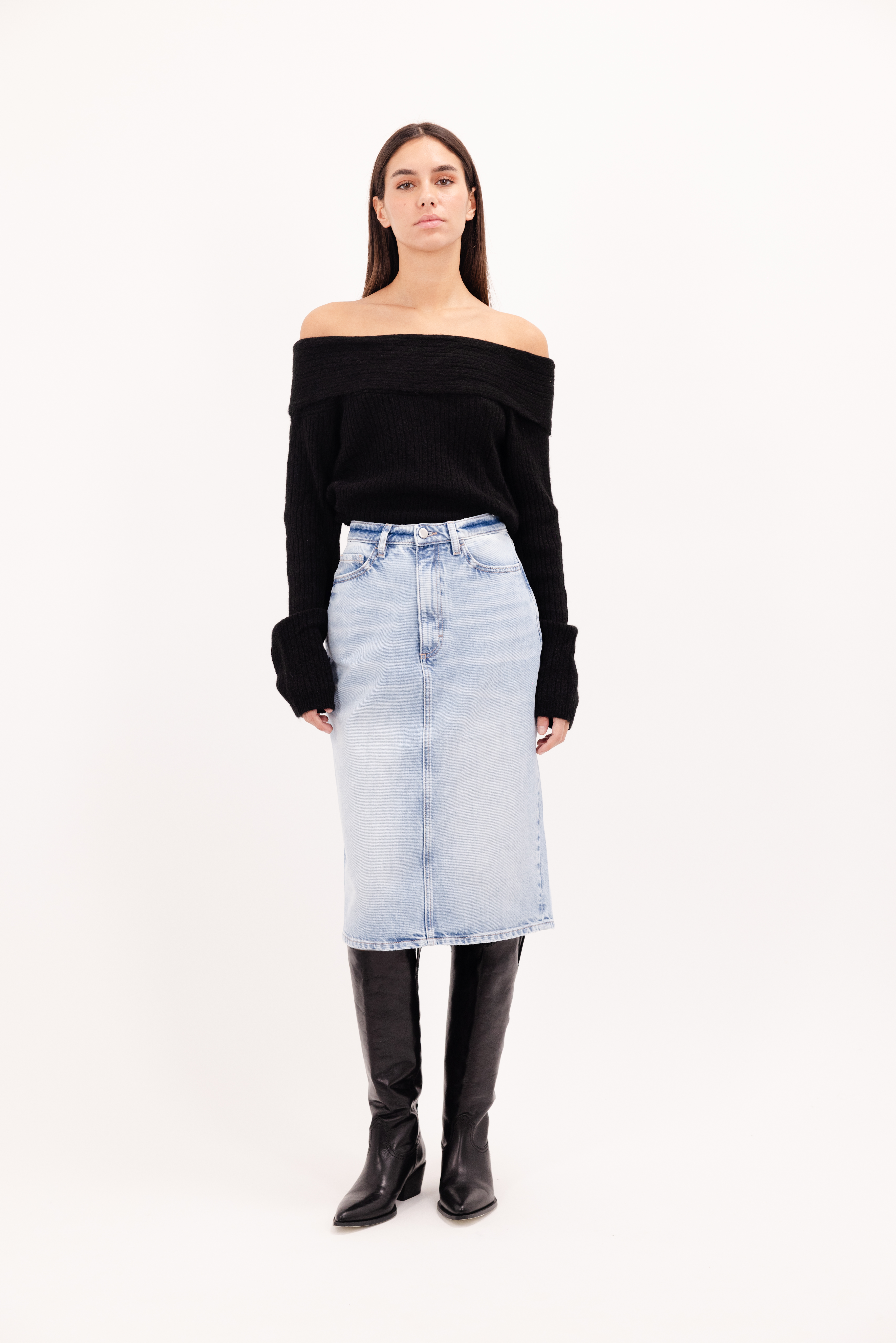 Ruby women’s midi skirt in sky blue wash, 100% rigid cotton denim, worn by a model with a black top.
