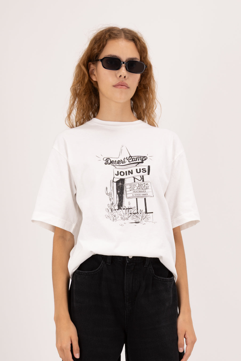 Sammy women’s t-shirt in white, 100% cotton, worn by a model with jeans.
