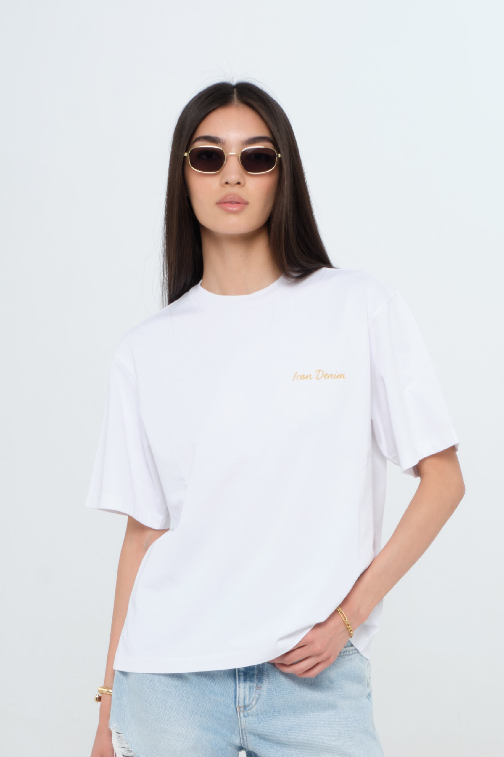 Sammy women’s t-shirt in white, 100% cotton, worn by a model with shorts.
