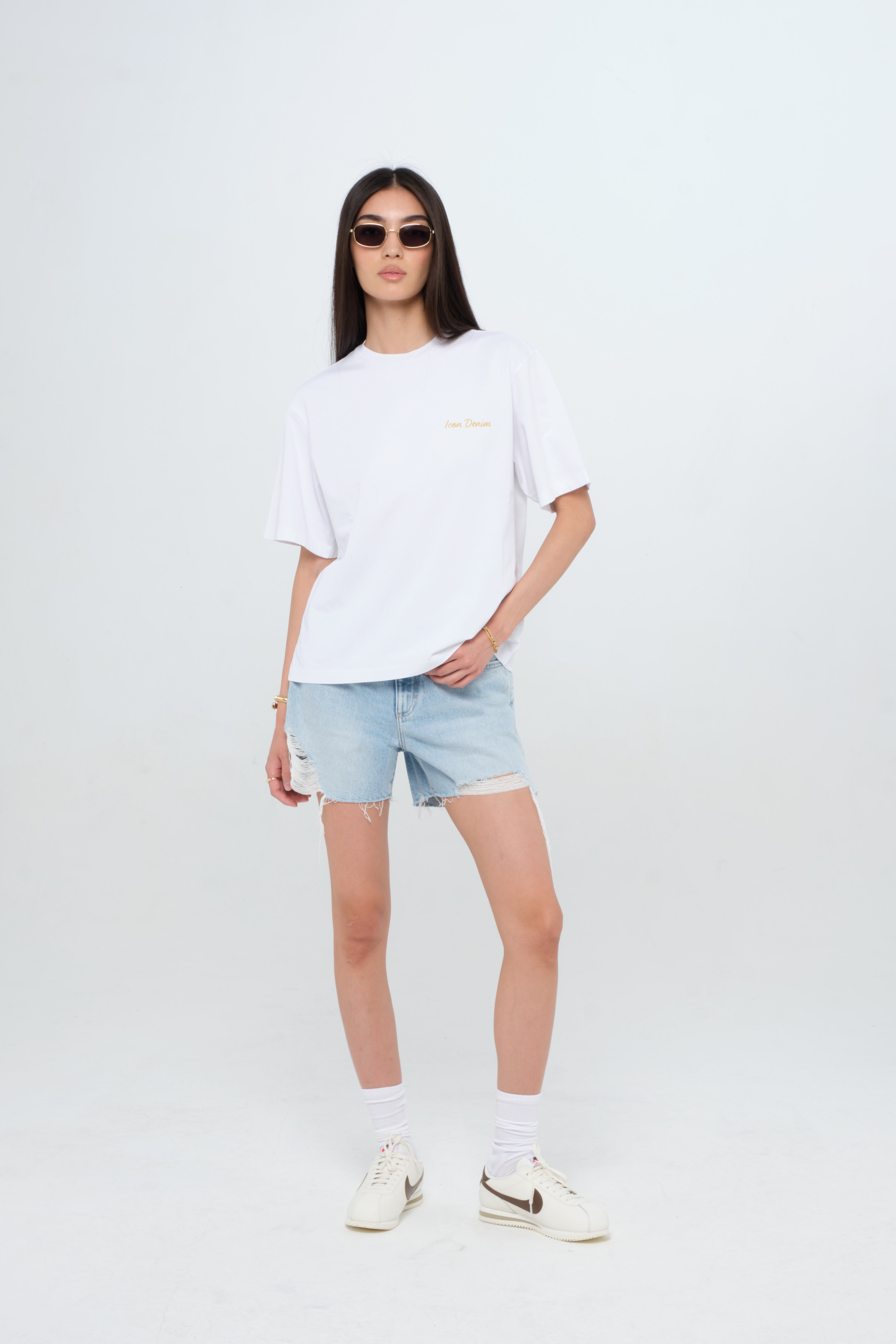 Sammy women’s t-shirt in white, 100% cotton, worn by a model with shorts.
