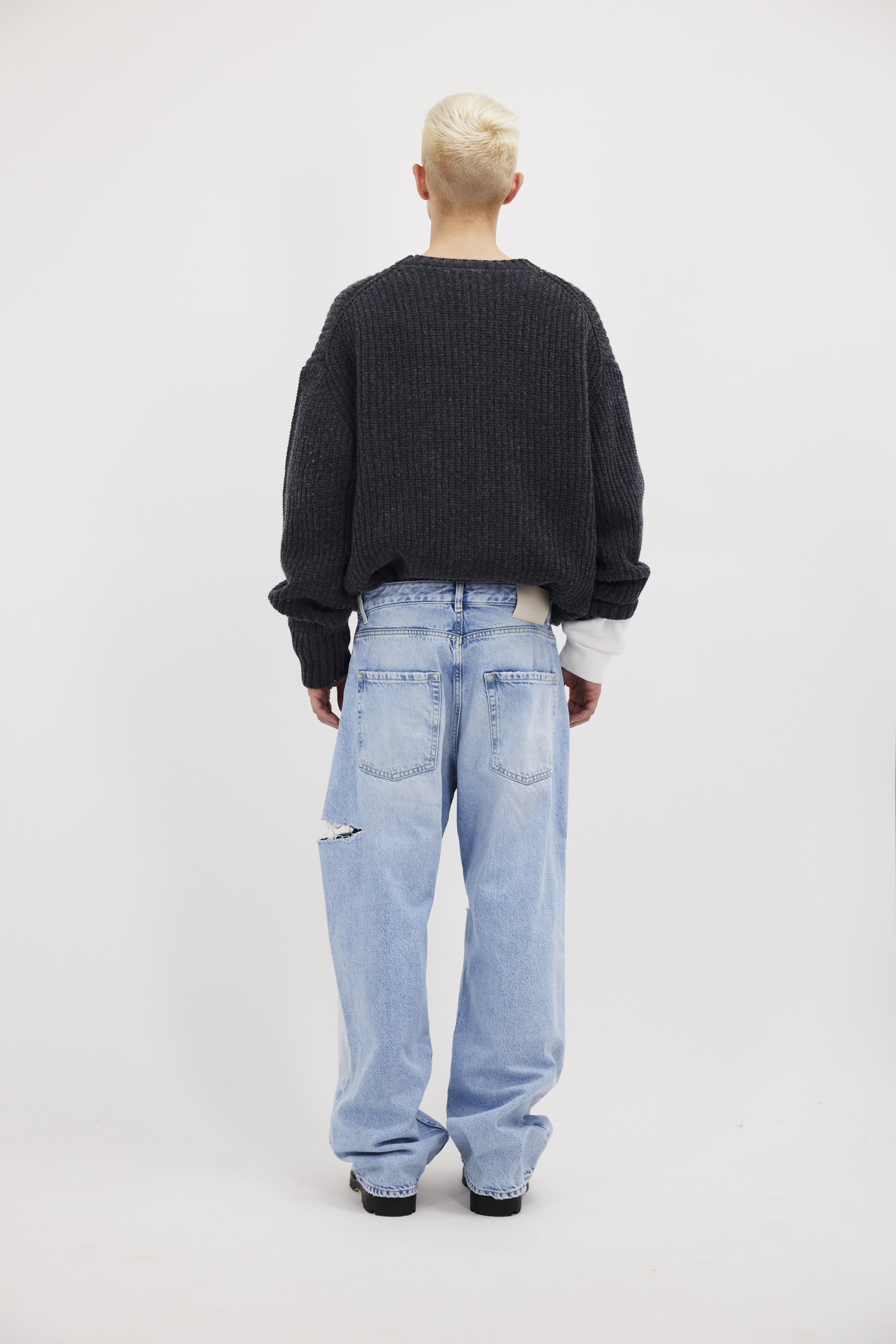Back view of Scott men’s wide leg jeans in sky blue wash, 100% rigid cotton denim, worn by a model with a grey knit.