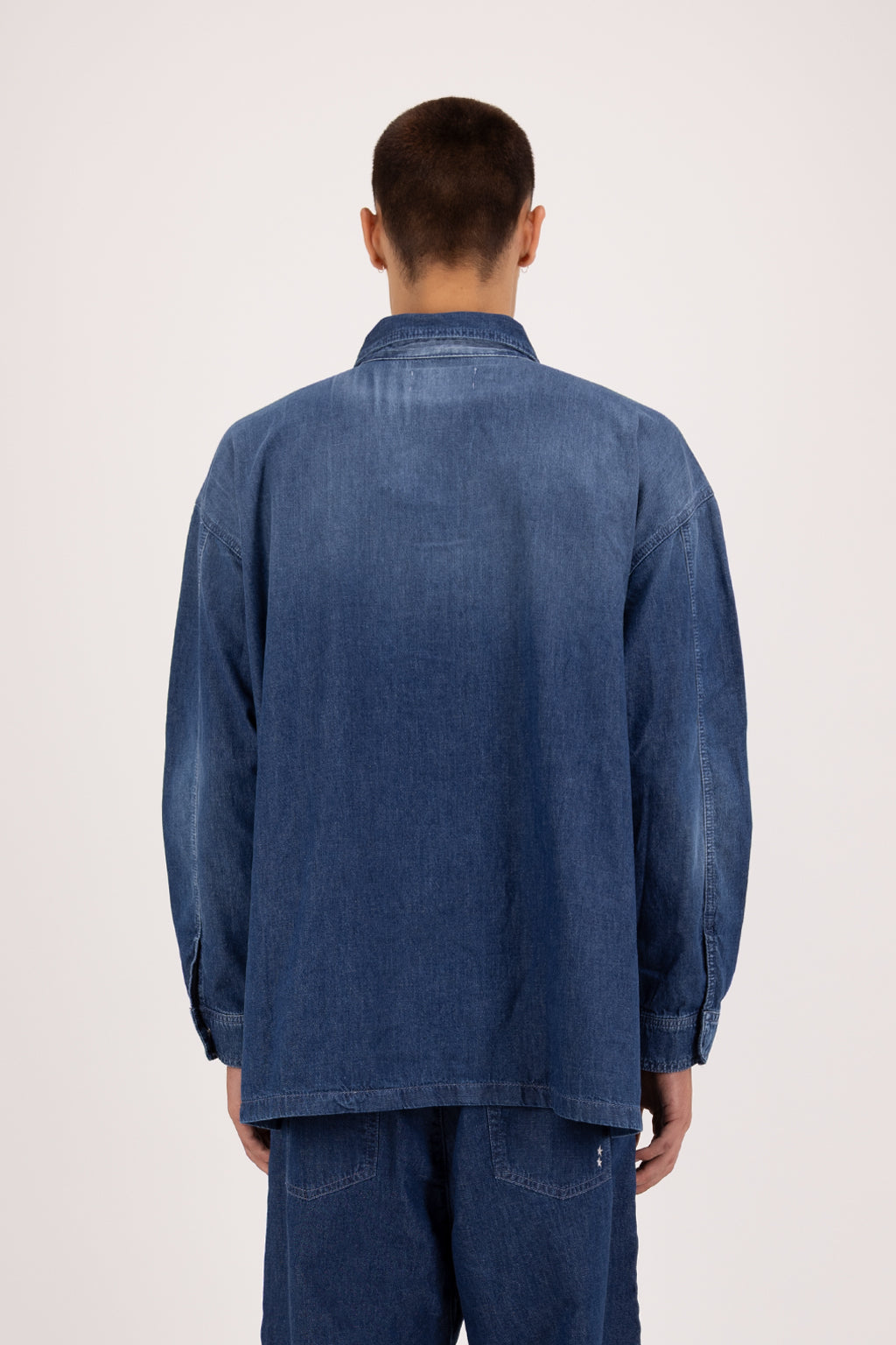 Back view of Seth men’s oversize shirt in night wash, 100% ultra light cotton denim, worn by a model with jeans.