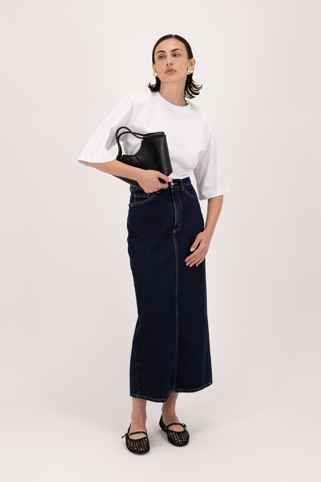 Suki women’s straight skirt in deep blue wash, 100% rigid cotton denim, worn by a model with a white t-shirt.