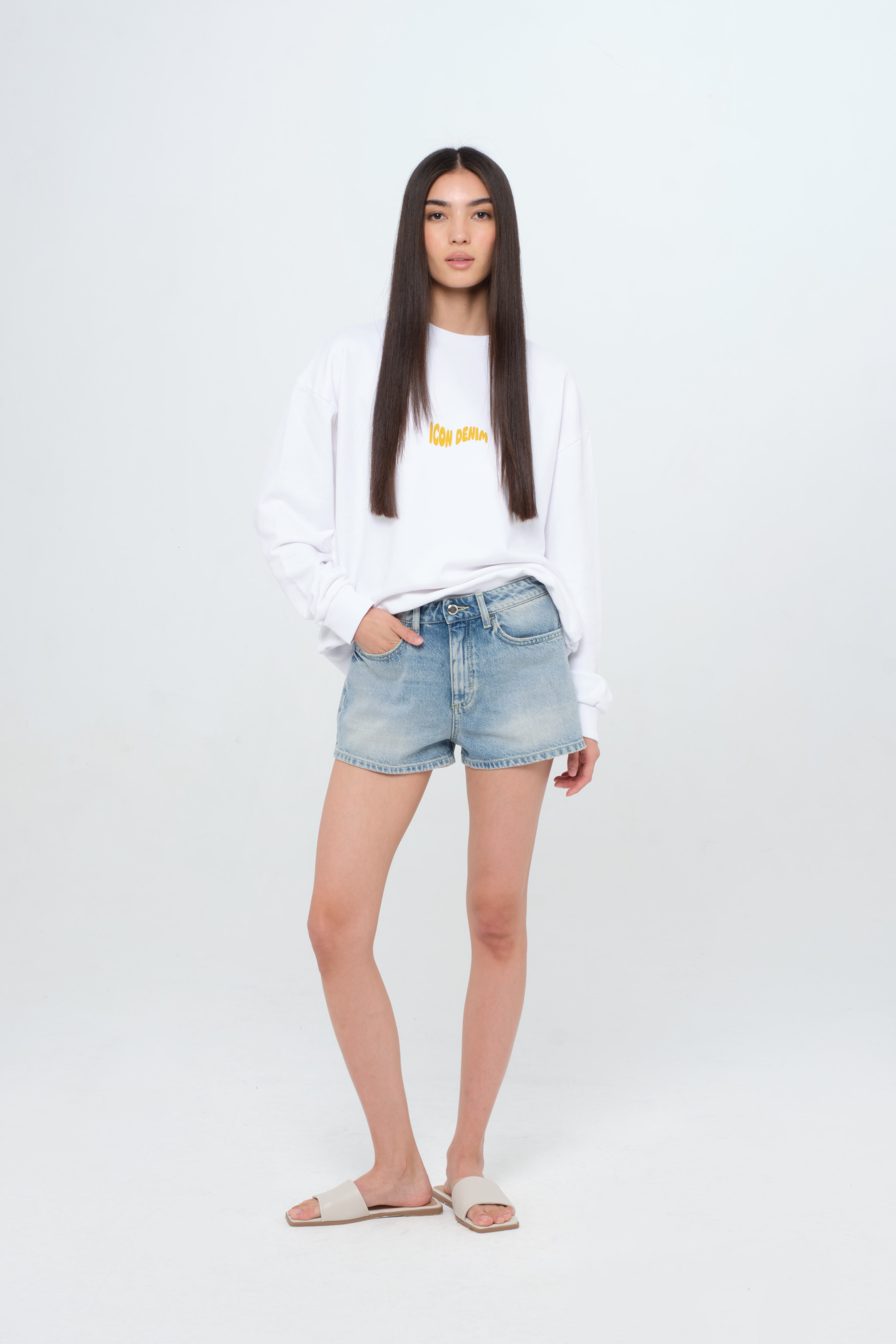 Tam women’s straight leg short jeans in smoke blue wash, 100% rigid cotton denim, worn by a model with a white sweatshirt.
