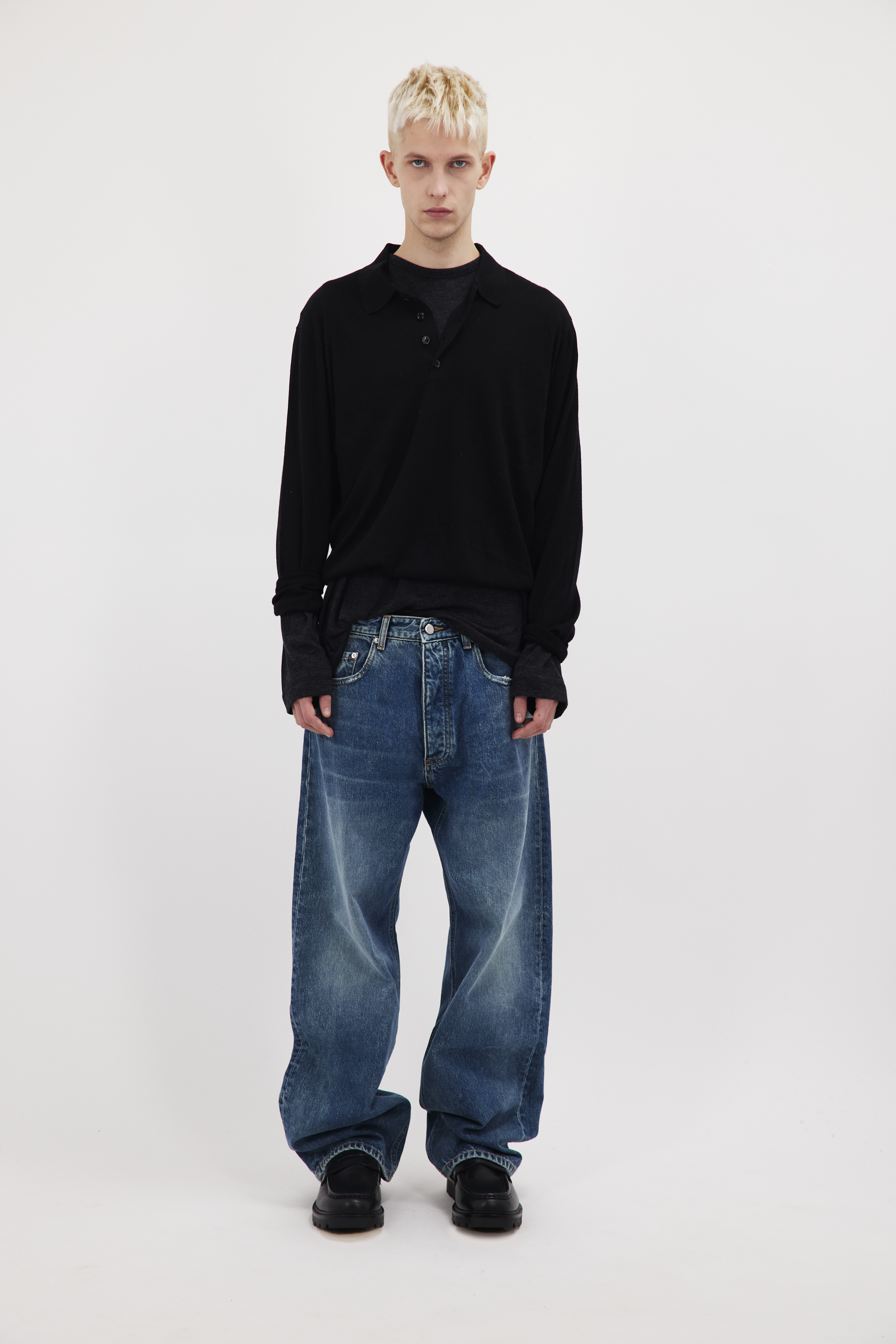 Will men’s wide leg jeans in aged stone wash, 100% rigid cotton denim, worn by a model with a black longsleeve.