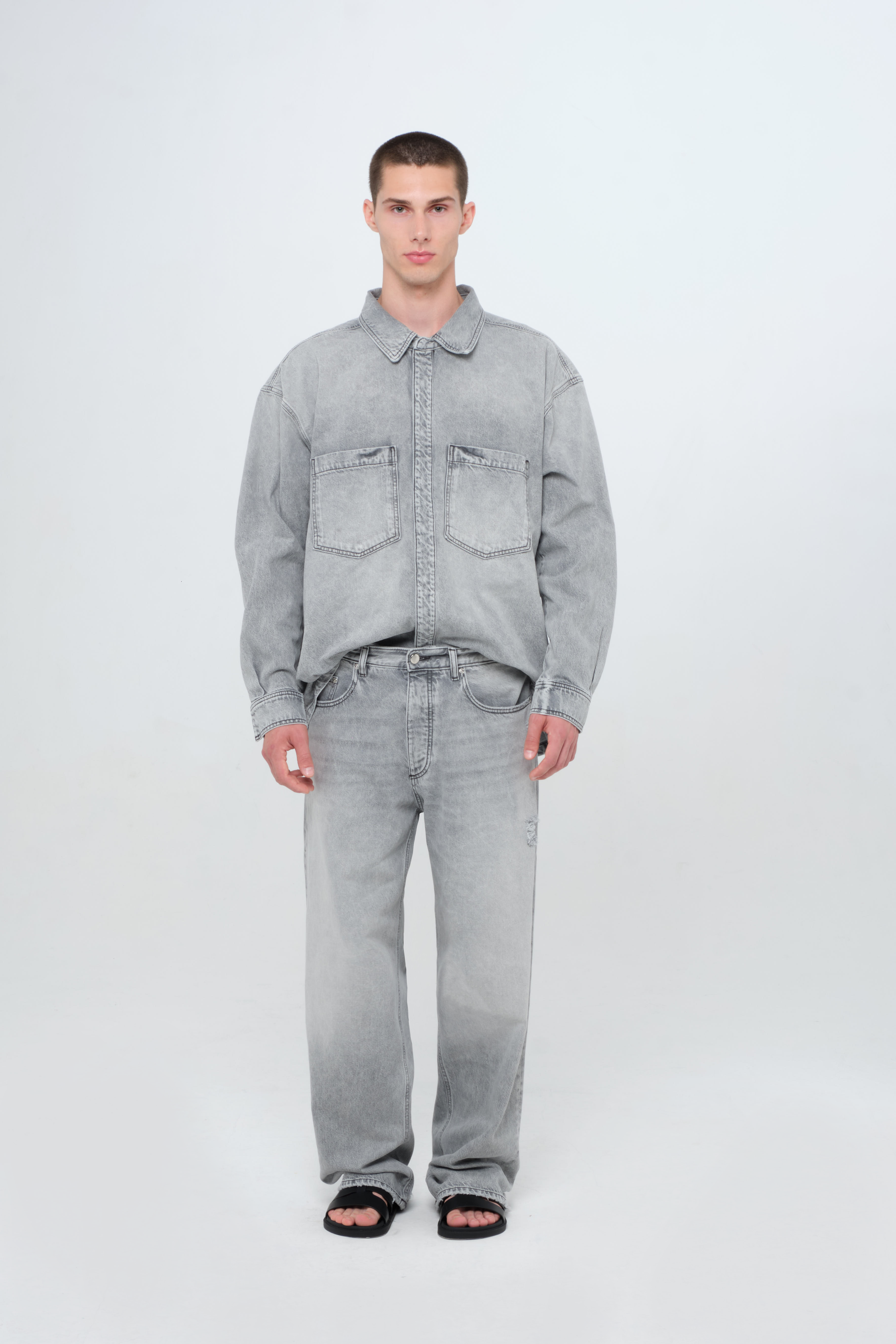 Will men’s wide leg jeans in gray wash, 100% rigid cotton denim, worn by a model with a denim shirt.